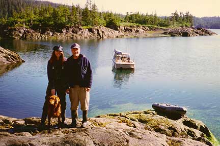 Dennis, Susan, the dog and the boat in a quiet cove.